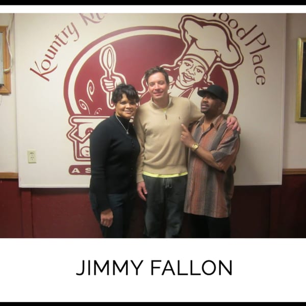 Jimmy Fallon with two Kountry Kitchen staff members in front of the restaurant's logo.