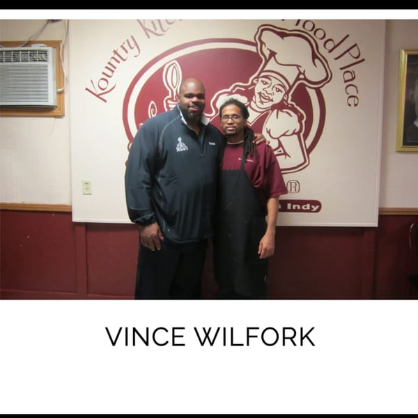 Vince Wilfork and a Kountry Kitchen staff member pose in front of the restaurant's logo.