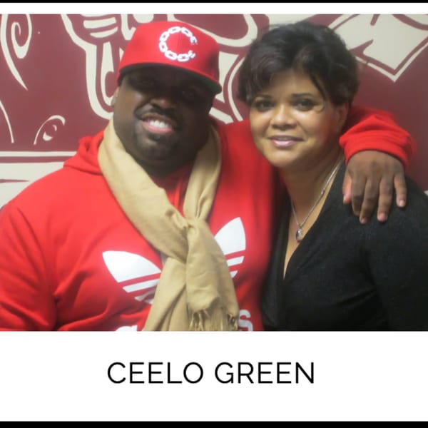 CeeLo Green in a red hoodie and cap, smiling with a woman at Kountry Kitchen.
