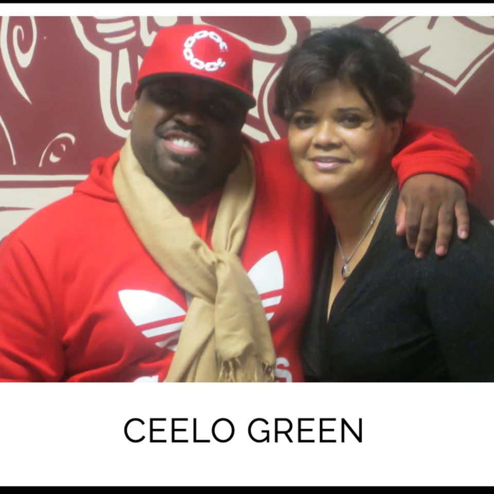 CeeLo Green in a red hoodie and cap, smiling with a woman at Kountry Kitchen.