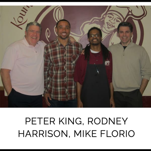 Four men, including Rodney Harrison, smiling in front of a Kountry Kitchen logo.